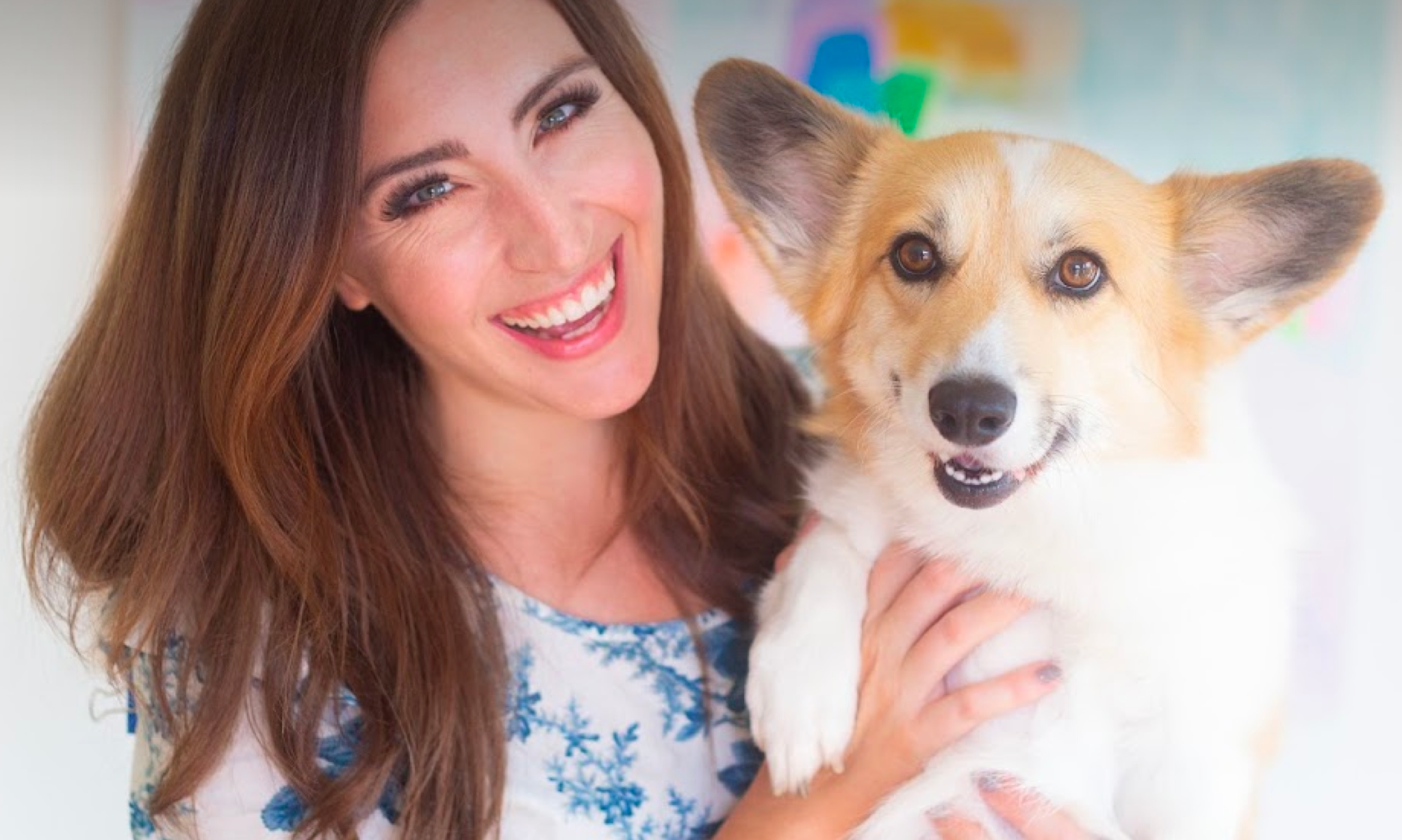 A young woman poses with her corgi