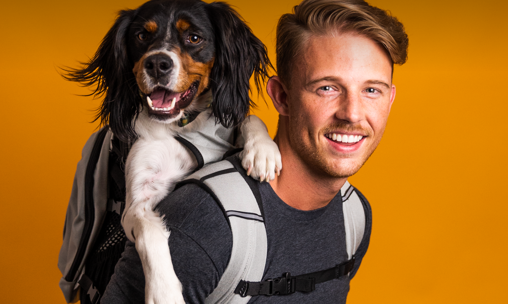 A happy young man and happy dog using a K9 Sport Sack Plus 2 backpack carrier