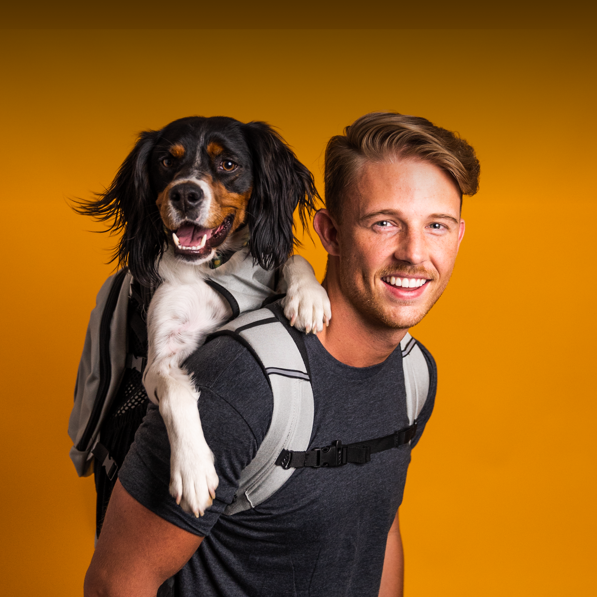 A happy young man and happy dog using a K9 Sport Sack Plus 2 backpack carrier