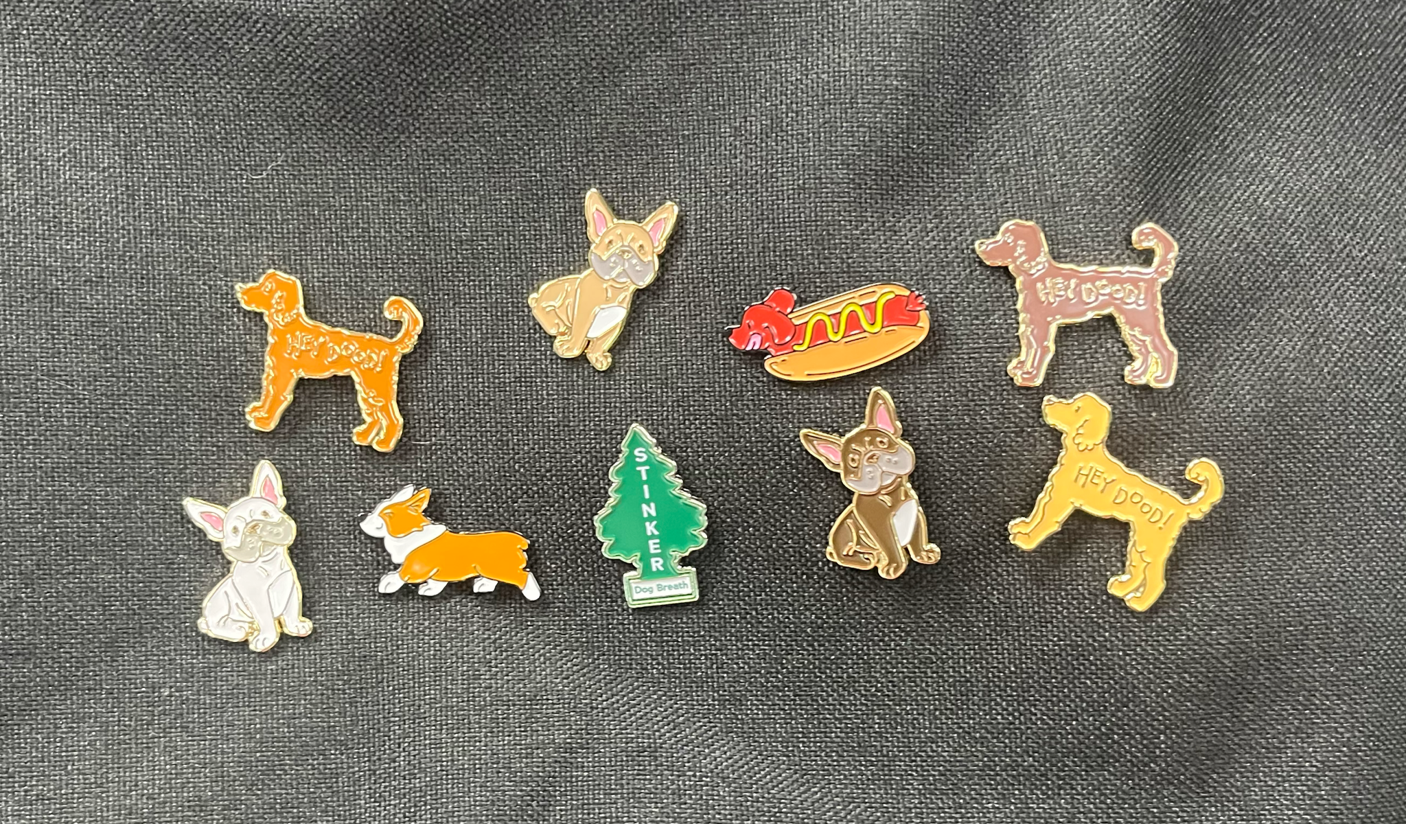 A group of dog related pins displayed on fabric